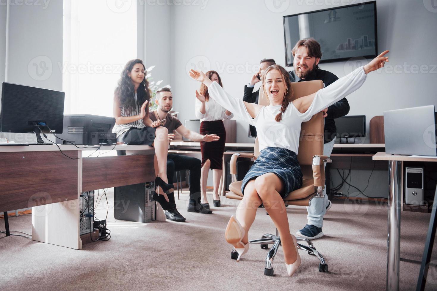 un grupo de empresarios celebrando, divirtiéndose, en la oficina. foto