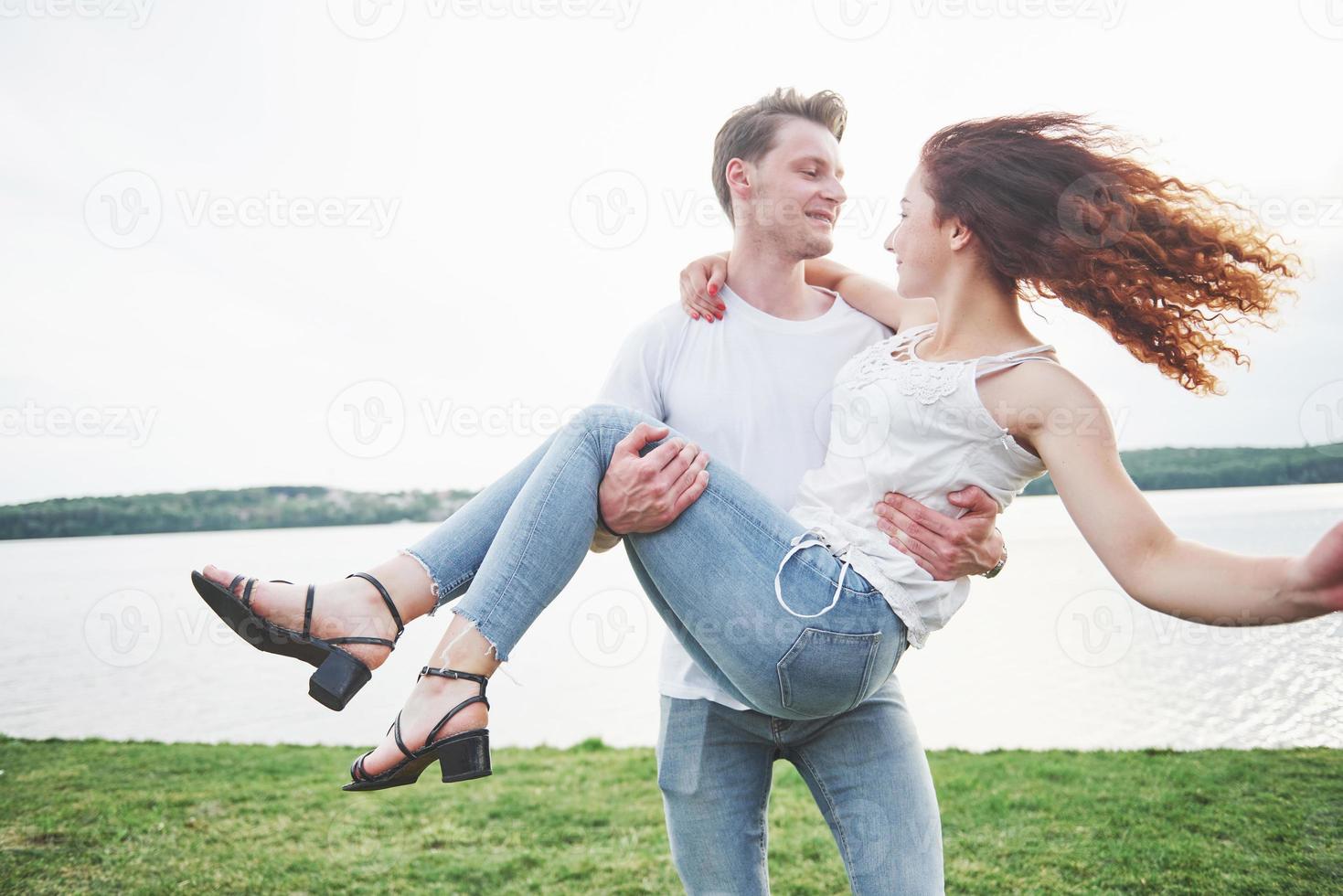 Feliz pareja joven disfrutando de una playa solitaria backriding foto