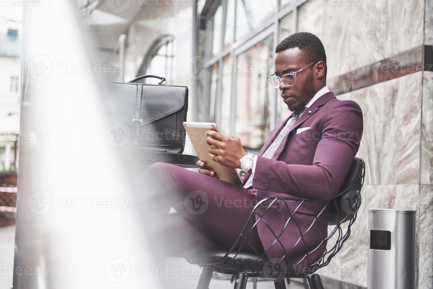 un hermoso empresario afroamericano lee un menú en un café foto