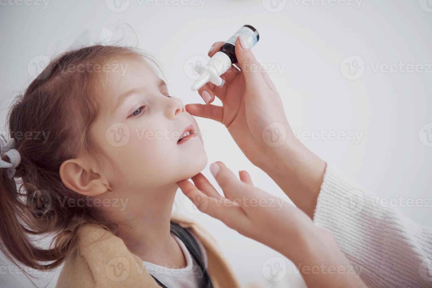 the girl drips into her nose with a spray of cold photo