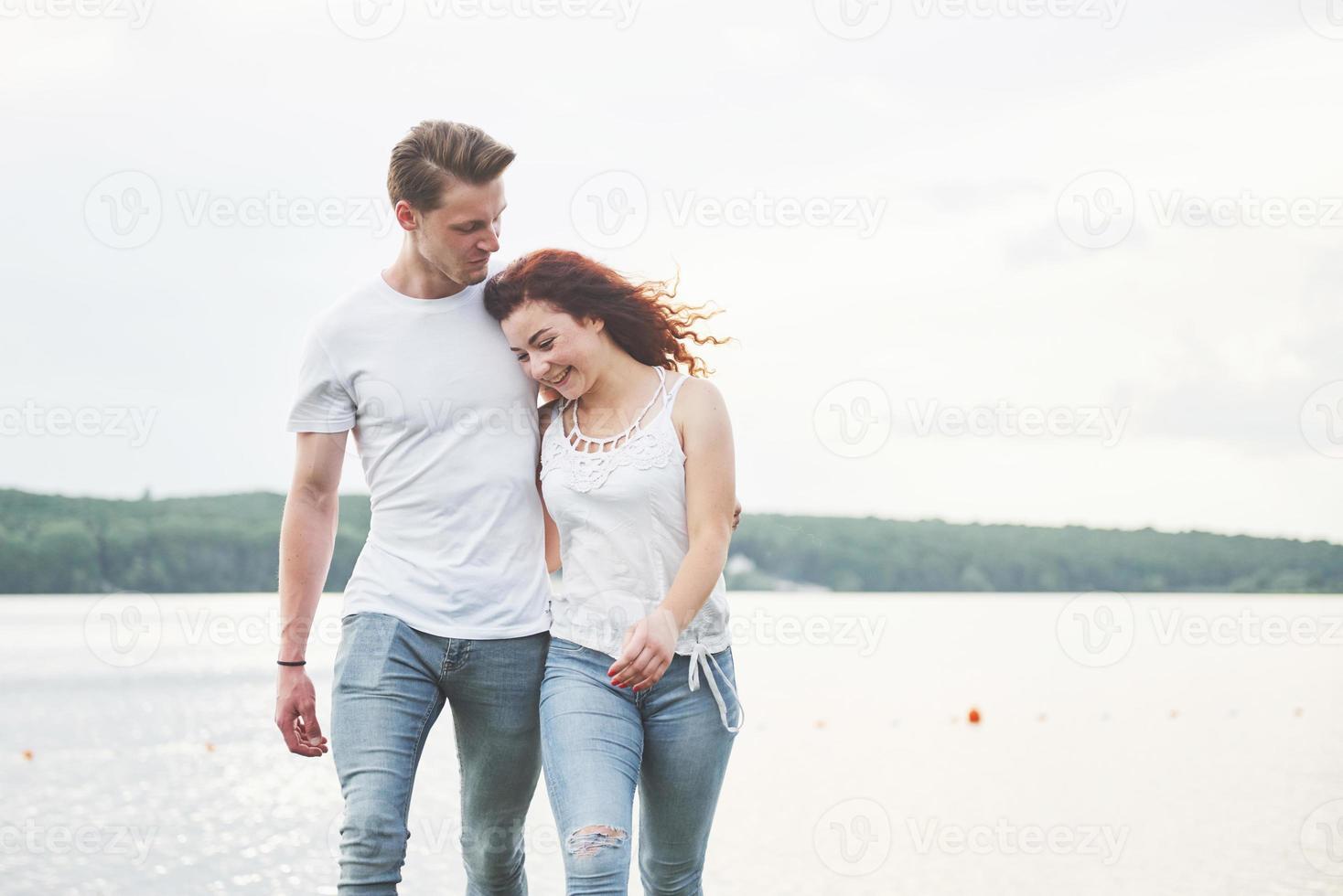 Feliz pareja joven disfrutando de una playa solitaria backriding foto