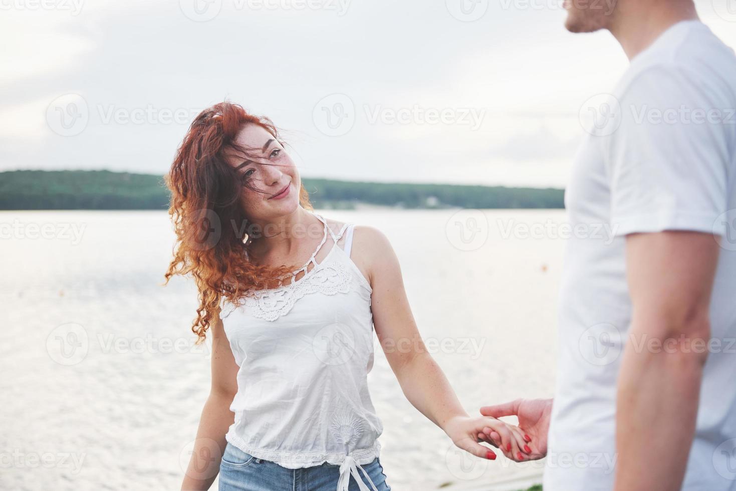 Feliz pareja joven disfrutando de una playa solitaria backriding foto