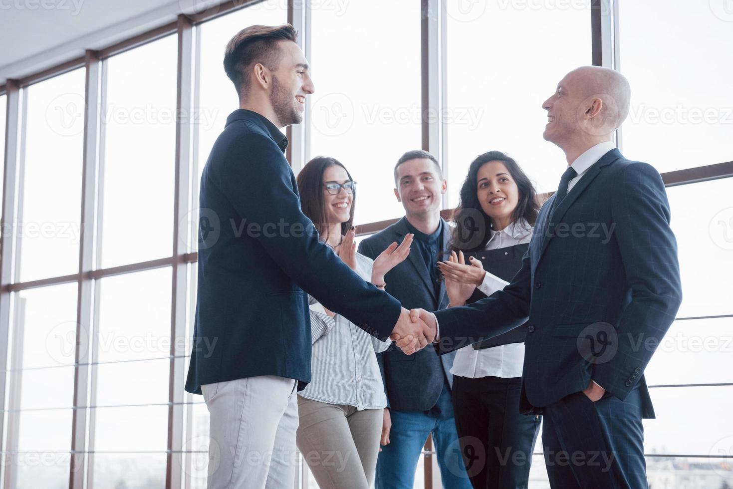 Dos hombre de negocios confiado dándose la mano durante una reunión en la oficina, el éxito, el trato, el saludo y el concepto de socio foto