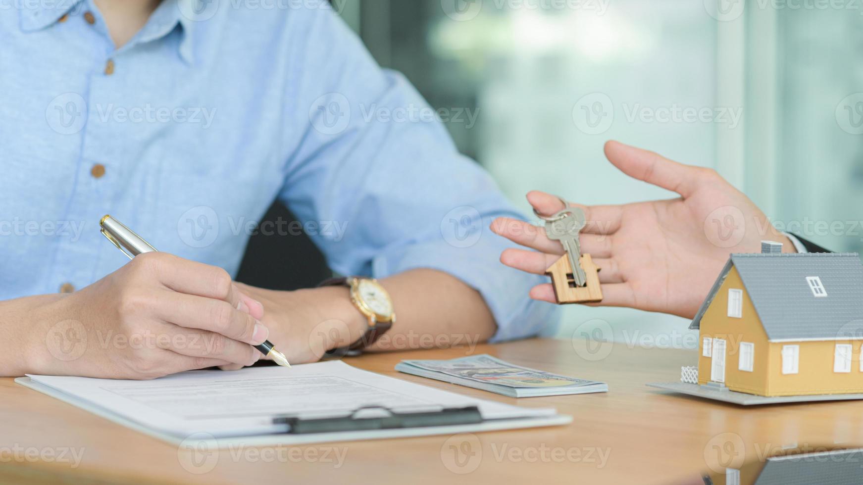 los agentes de seguros están introduciendo a los clientes a firmar contratos de seguros inmobiliarios. foto