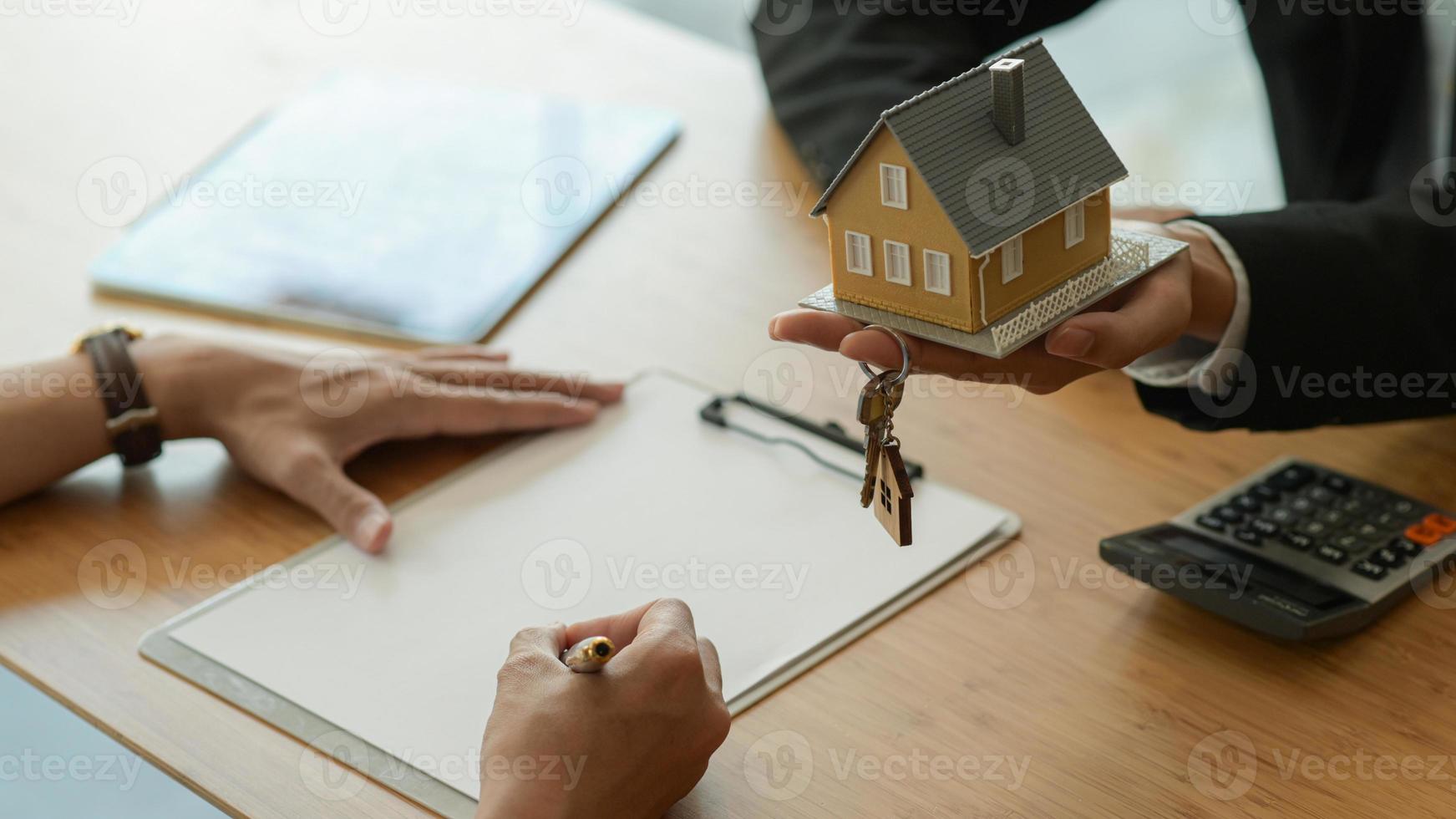 House broker is introducing the client to sign the purchase contract. photo