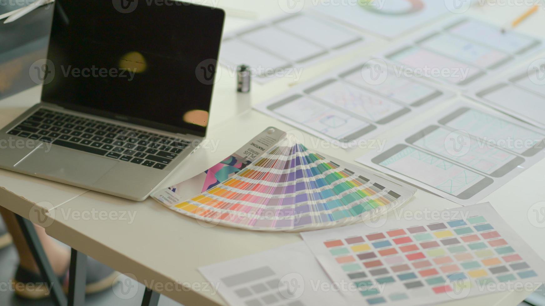 Laptops with color charts and equipment on the desk for the UX team to design apps in a modern office. photo