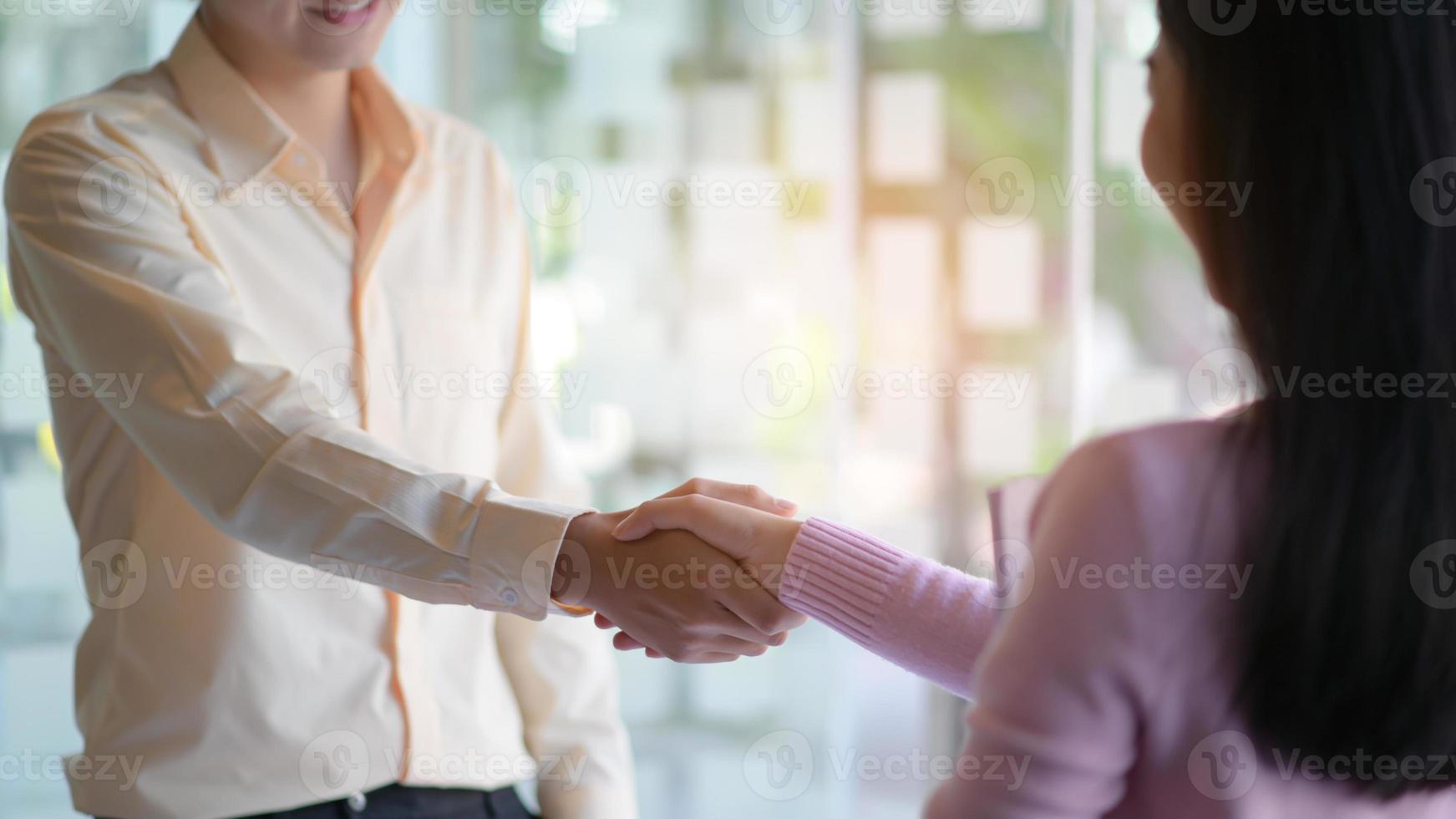 los nuevos empleados se dan la mano para trabajar juntos en la oficina moderna. foto