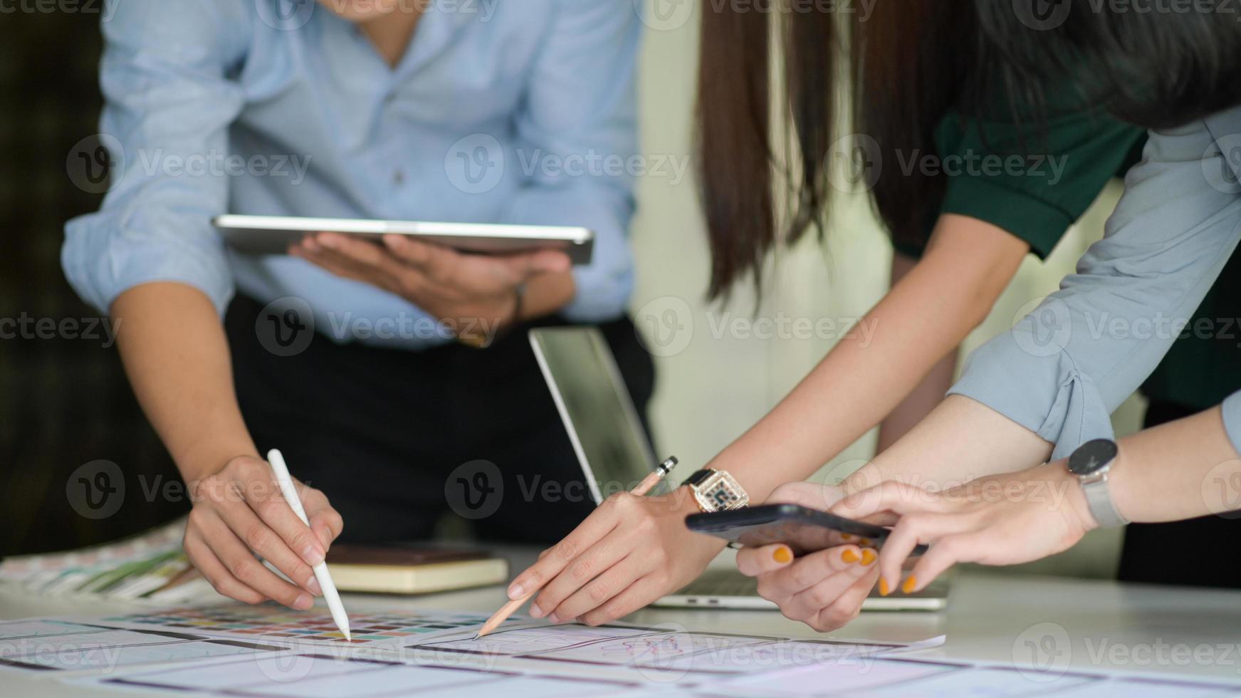 The UX team is designing an application for smartphones with a laptop in a modern office. photo