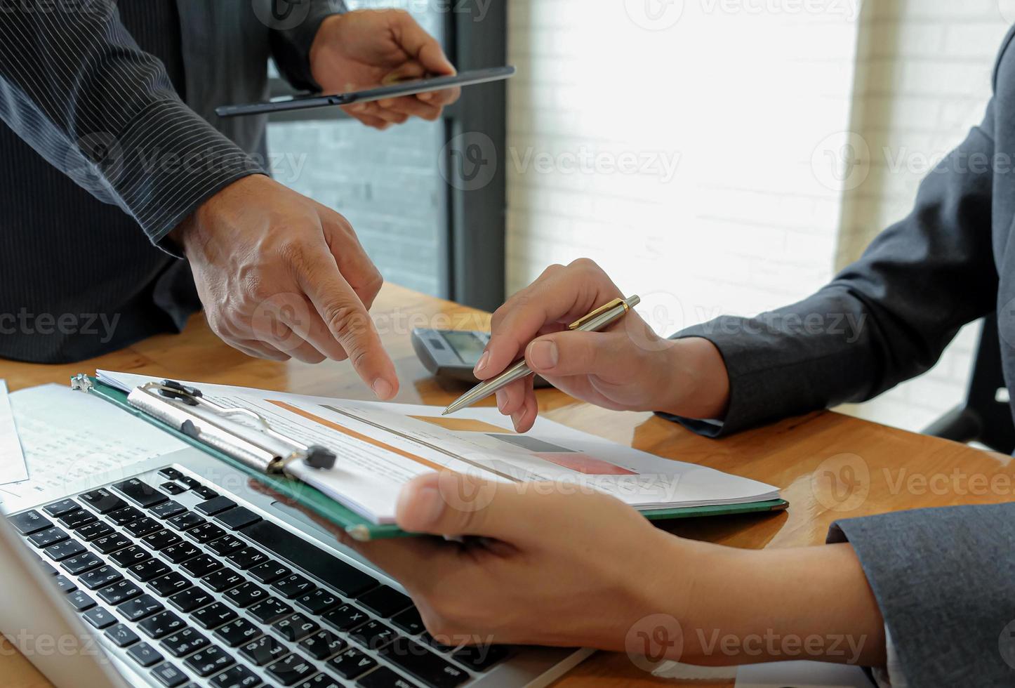 Team of business using pen, laptop, are planning a marketing plan to improve the quality of organization in the future. photo