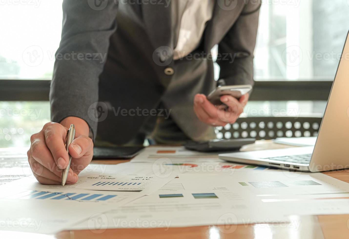 Los empresarios que utilizan bolígrafos, portátiles y teléfonos móviles están planificando un plan de marketing para mejorar la calidad del trabajo. foto