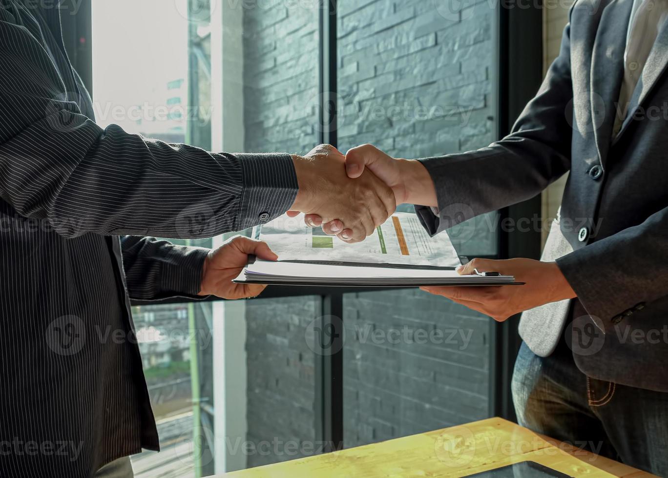 Businessman shakehand and exchanging contract documents. photo