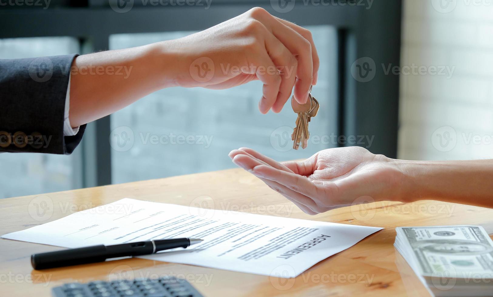 The house broker sends the keys to the customer after signing the contract to buy the house. photo