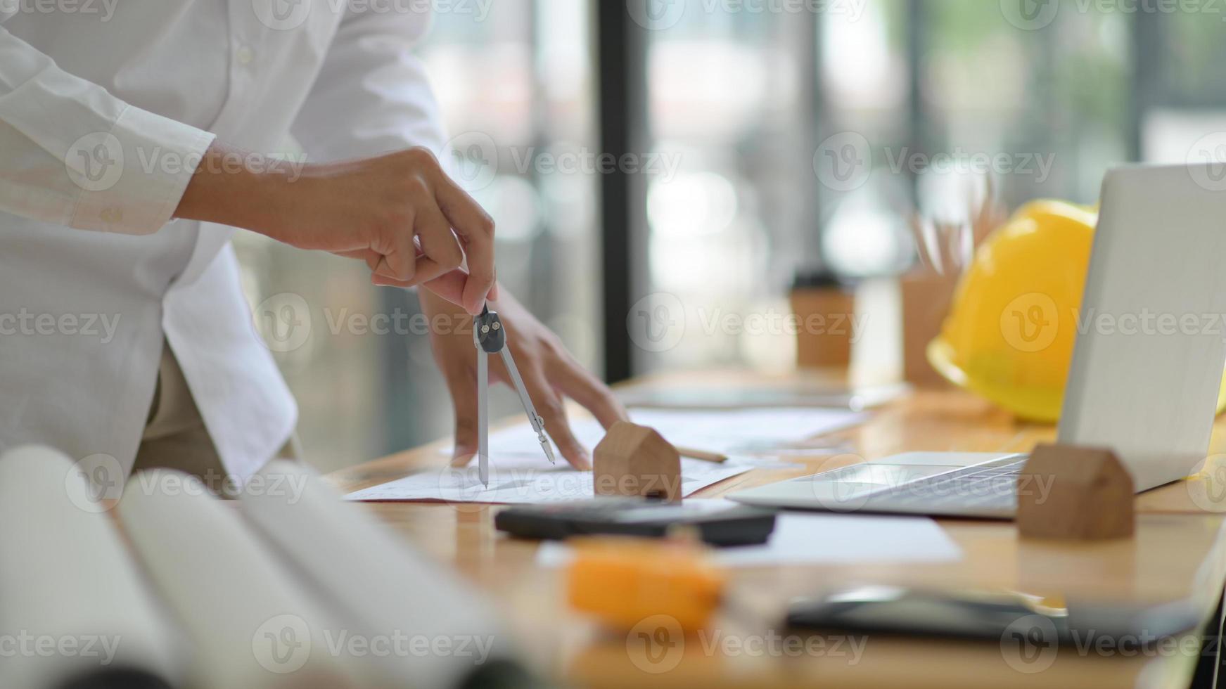 The architect is designing the construction. He drafts the floor plan to present to the client. photo