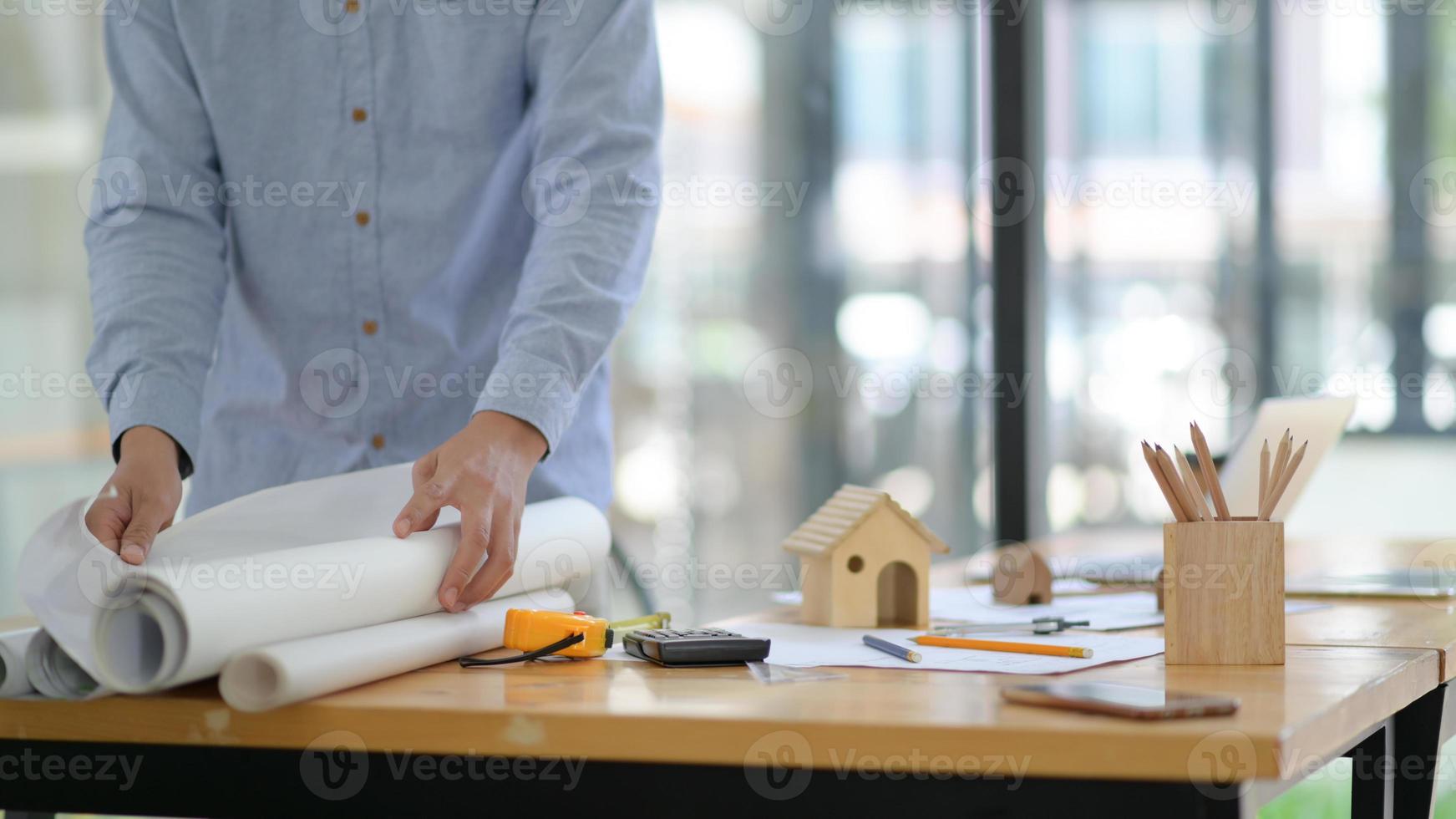The architect is collecting the construction plan to present the client. photo