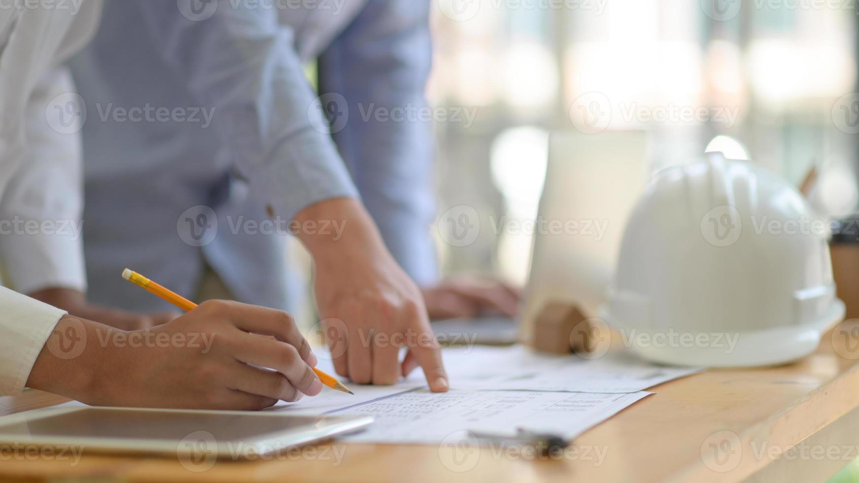 The architect is designing the construction. He drafts the floor plan to present to the client. photo