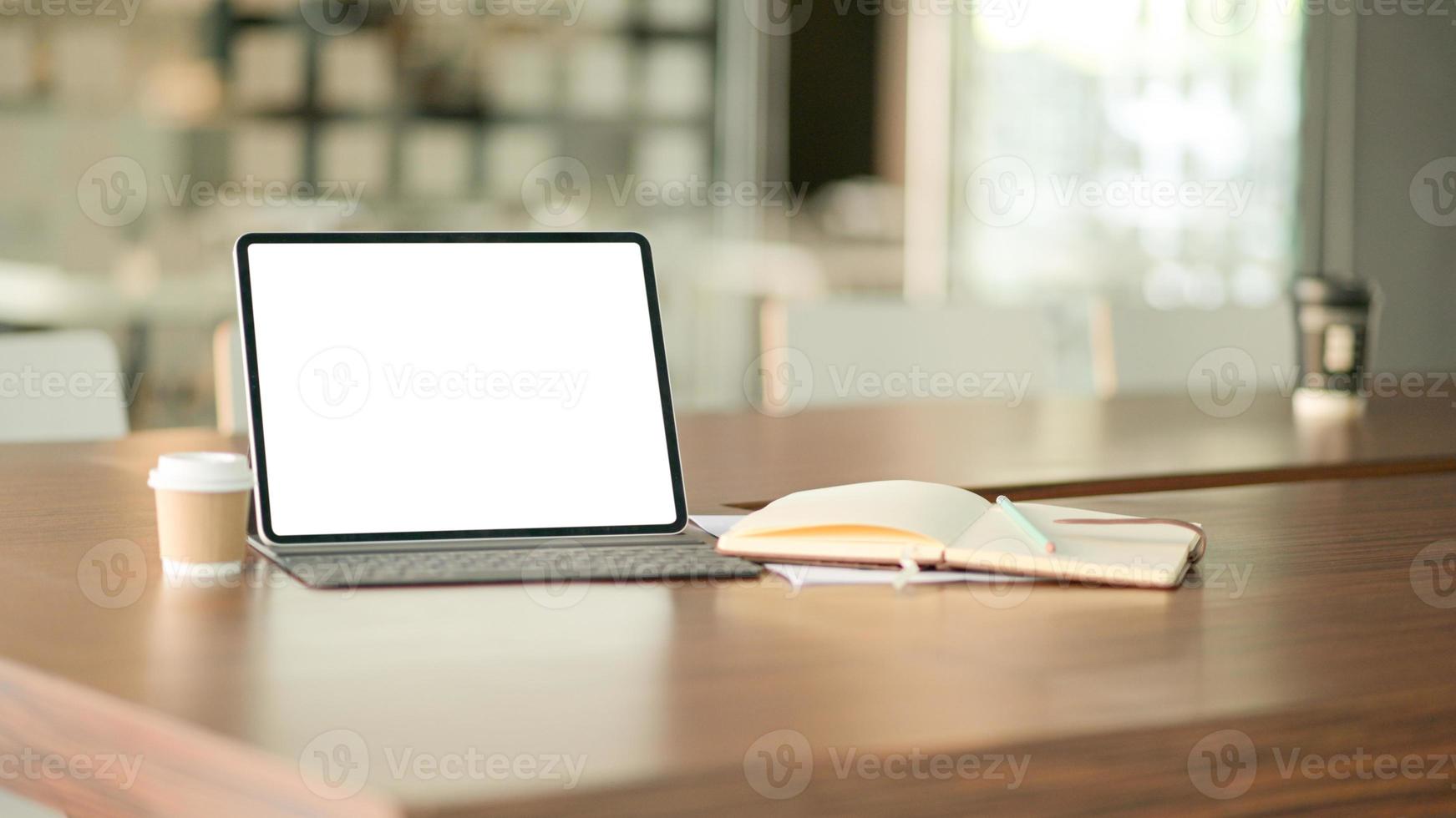 Blank screen laptop computer and a coffee in modern office with notebook. photo