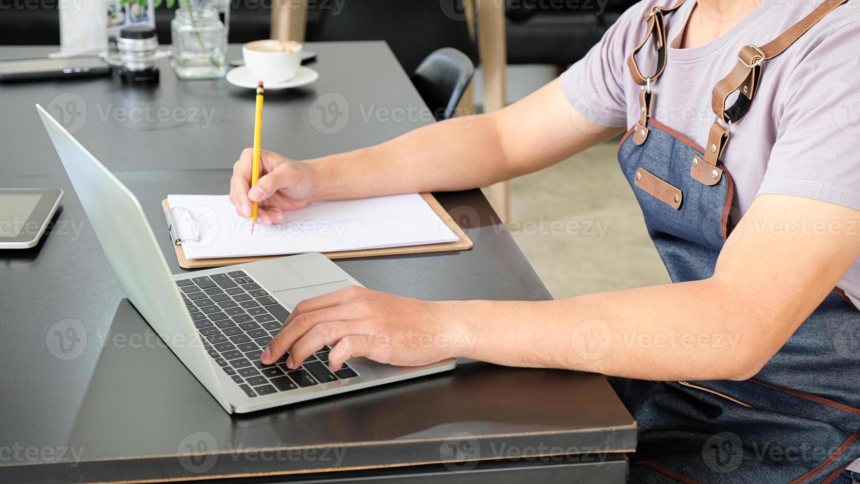 Employees are using laptop and recording daily sales. photo