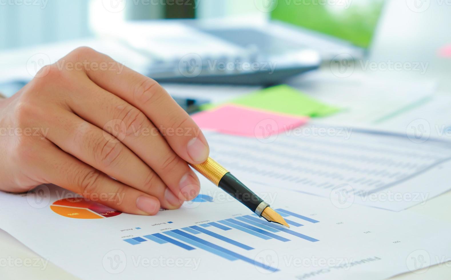 Close-up shot of Analysts use the pen to point the graph to assess the situation of the stock market that is fluctuating. photo