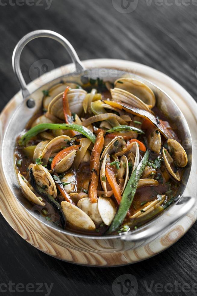 Estofado de almejas y verduras mediterráneas en una olla en el restaurante de Barcelona foto