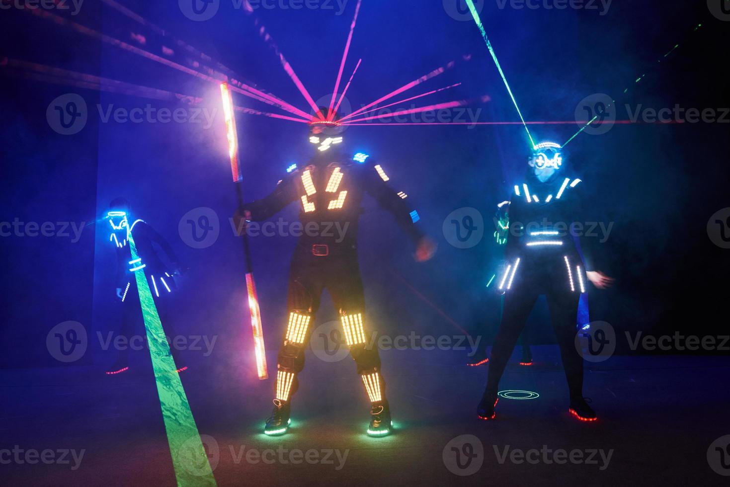 Laser show performance, dancers in led suits with LED lamp, very beautiful night club performance, party photo