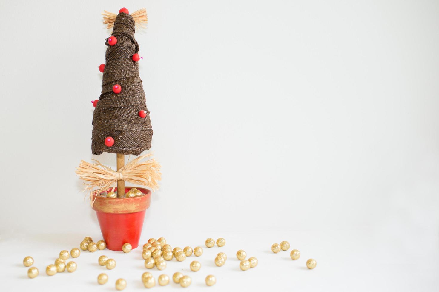 árbol de navidad y bolitas doradas con fondo blanco foto