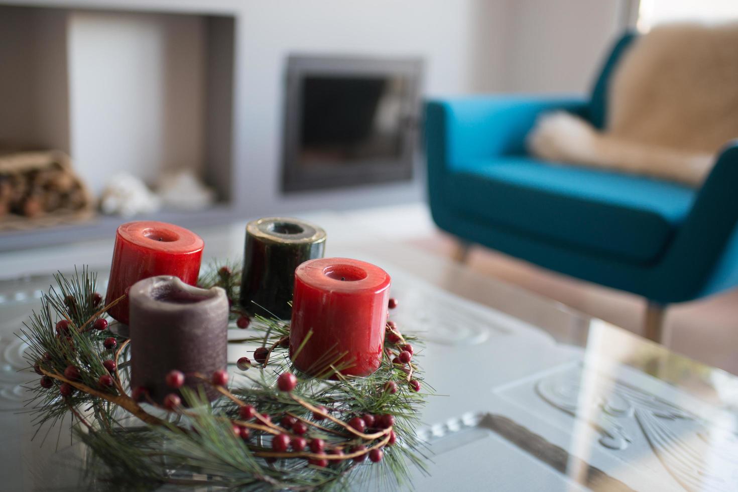 Christmas decoration in green and red colors. Advent crown with colorful candles. Modern living room with stove. Madrid, Spain photo