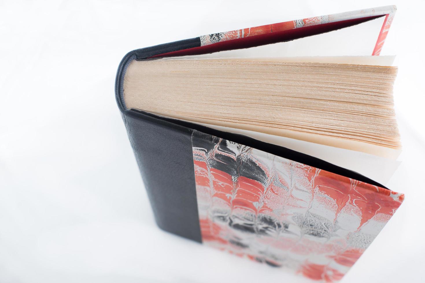 Beautiful hand binded book with leather and waterprint paper in red and black seen from above photo