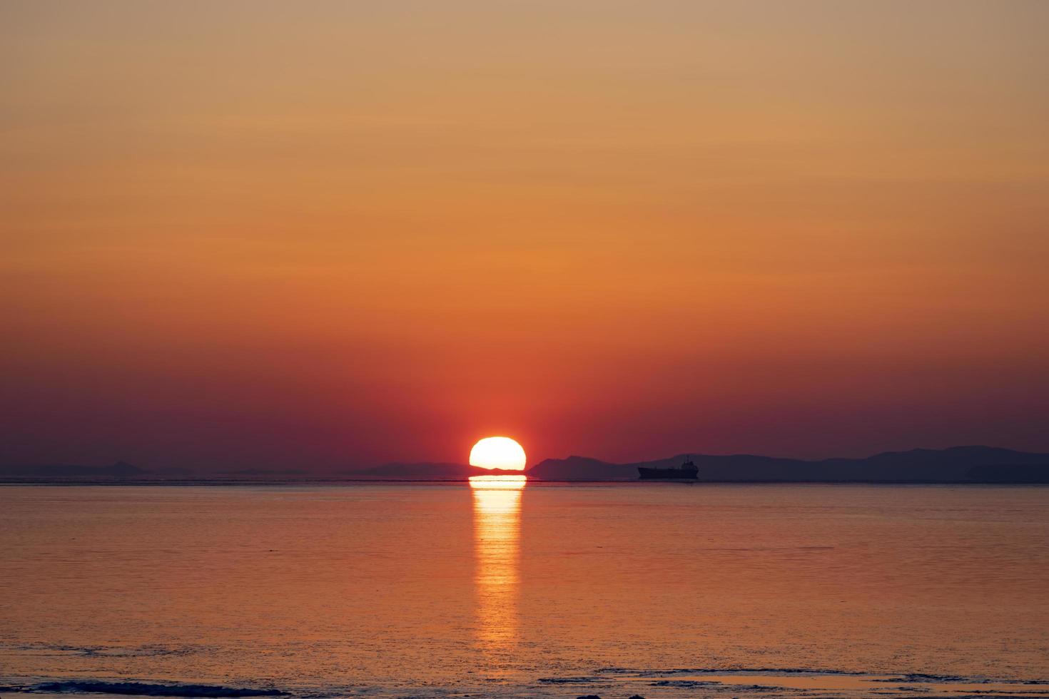 hermosa puesta de sol sobre el mar y la silueta del barco foto