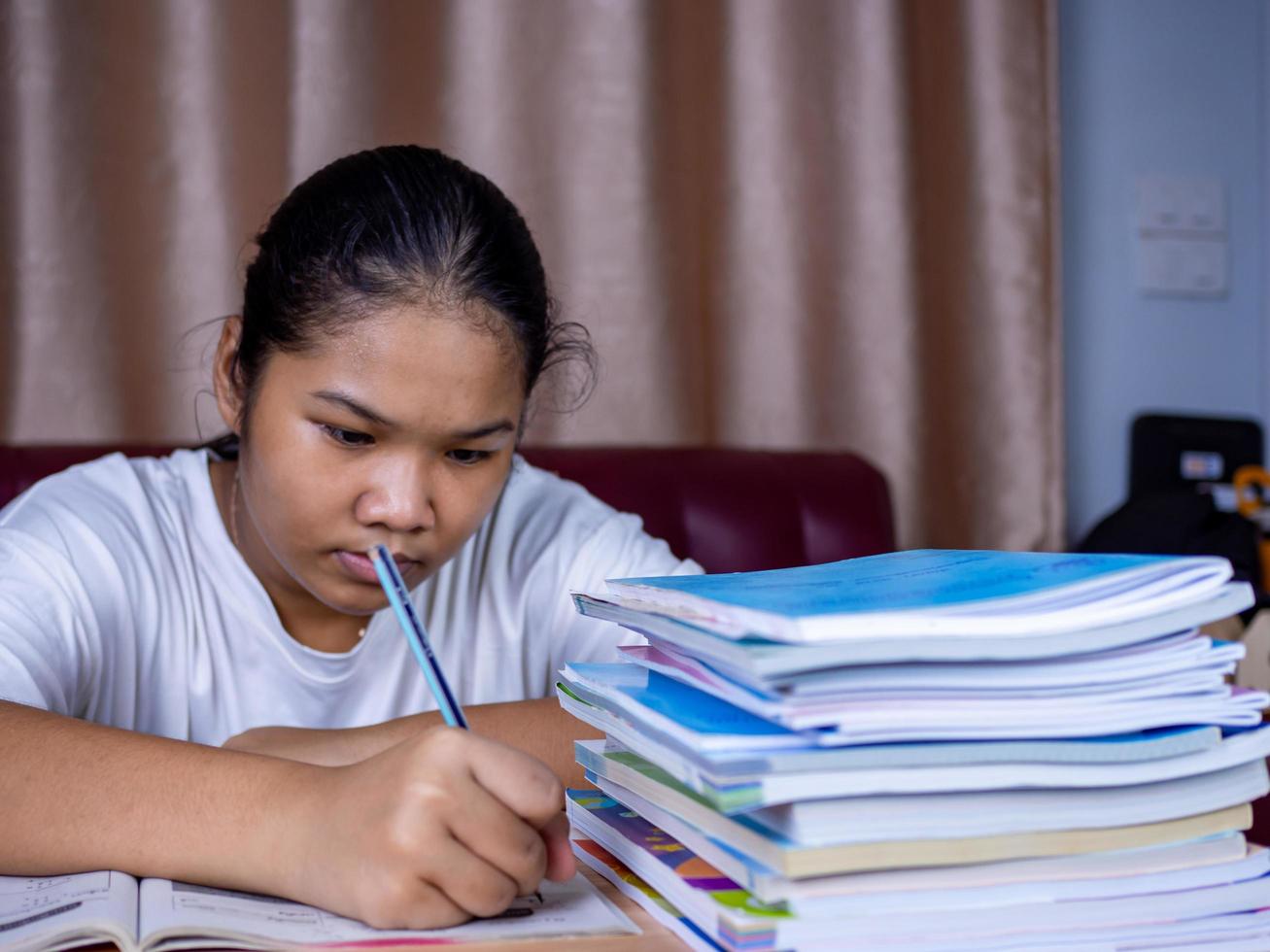 Girl doing homework on a wooden table photo