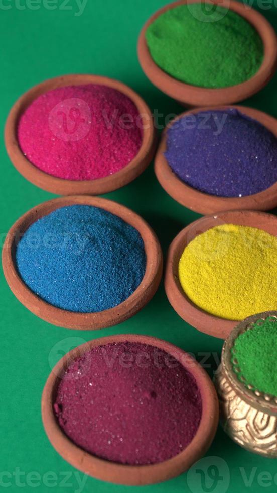 Diwali Festival showing Colourful rangoli in bowls,clay lamp or diya on background photo