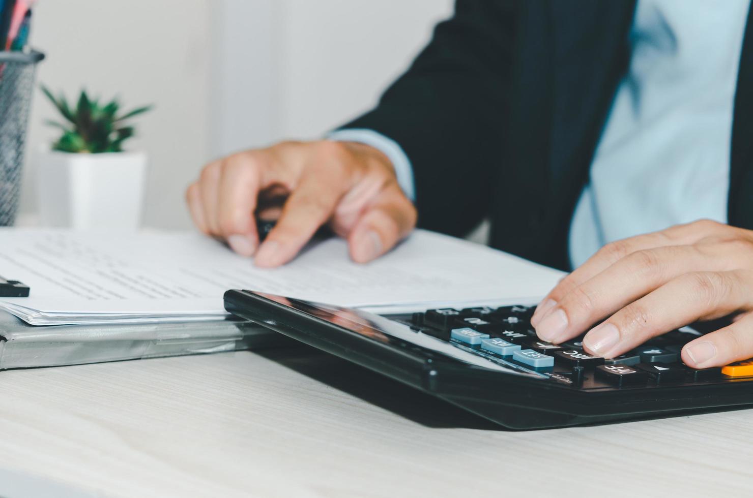 hombre de negocios con calculadora en un escritorio. conceptos de finanzas comerciales, impuestos e inversiones. foto