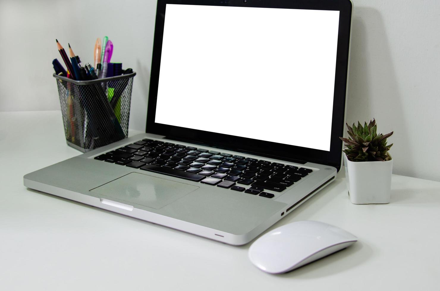 computadora portátil simulacro de blanco en blanco y ratón en el escritorio. se utiliza para poner texto o información para anunciar noticias o vender productos en línea. concepto de negocio de marketing foto