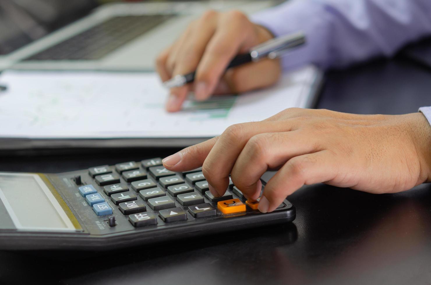 Mano de hombre de negocios presionando un concepto de negocio, finanzas, impuestos e inversión calculadora. foto