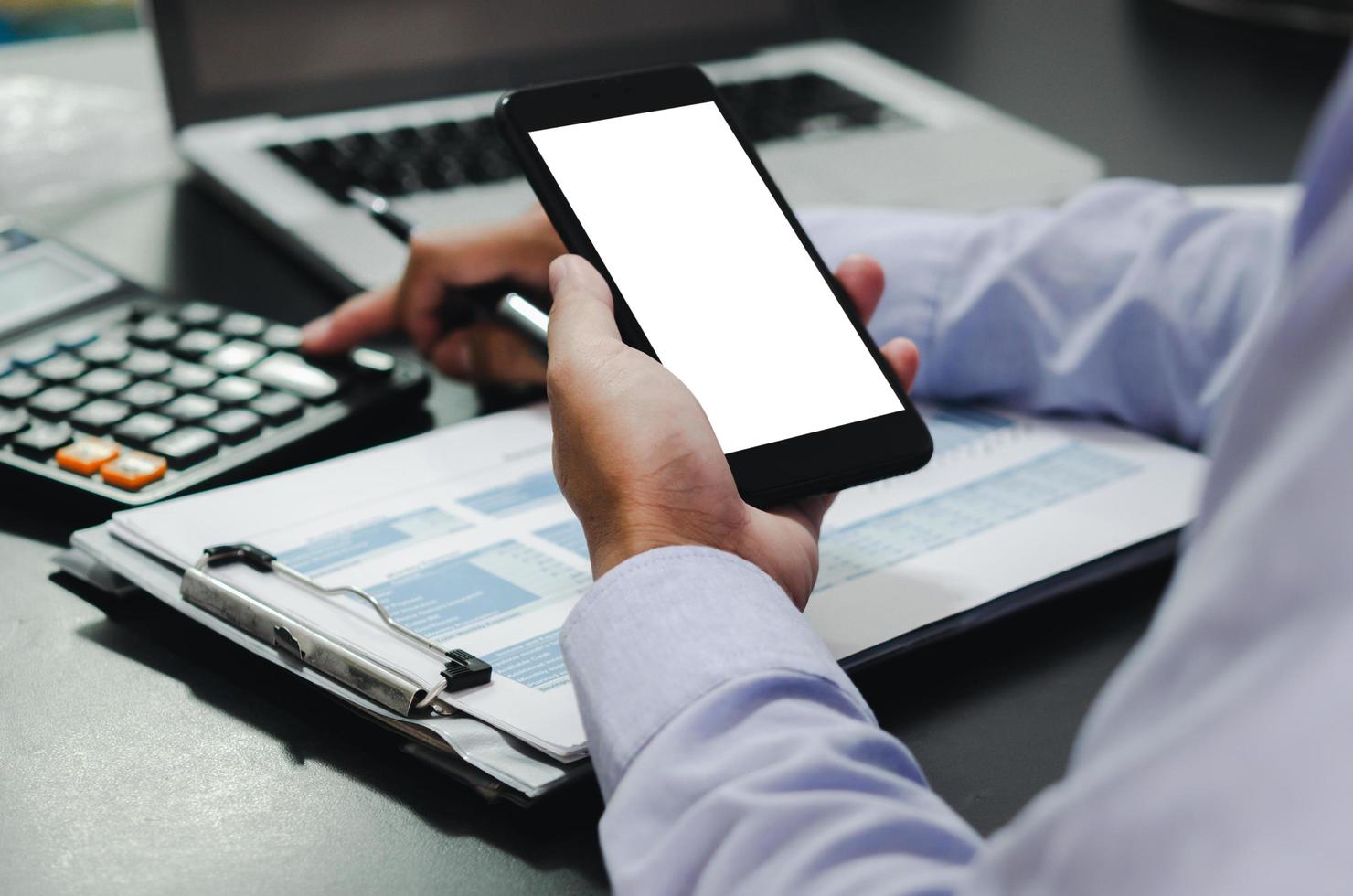 La mano del empresario sosteniendo un teléfono móvil con una pantalla de maqueta usa el espacio para colocar anuncios o imágenes. concepto de negocio de tecnología foto