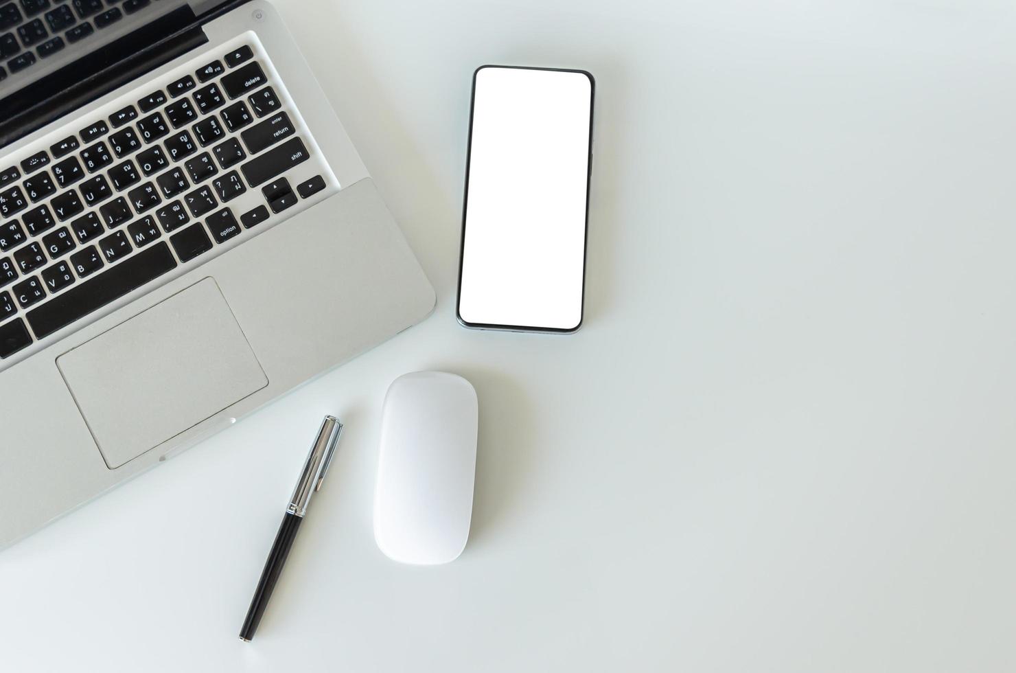 Top view mock up smartphone with mouse computer latop and pen.Copy space flatlay. photo