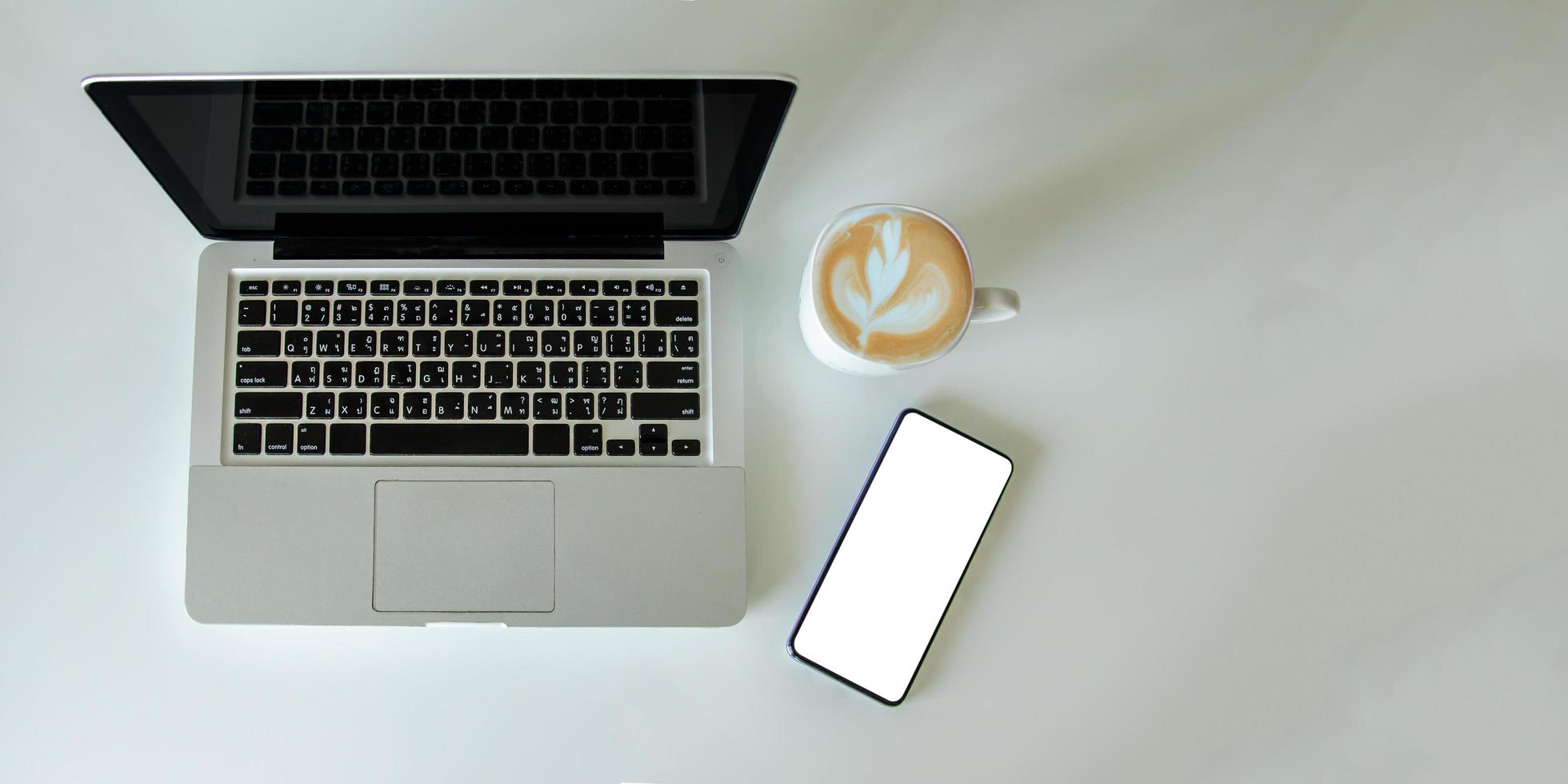 Top view mock up smartphone with mouse computer laptop and coffee cup.Copy space flat lay. photo