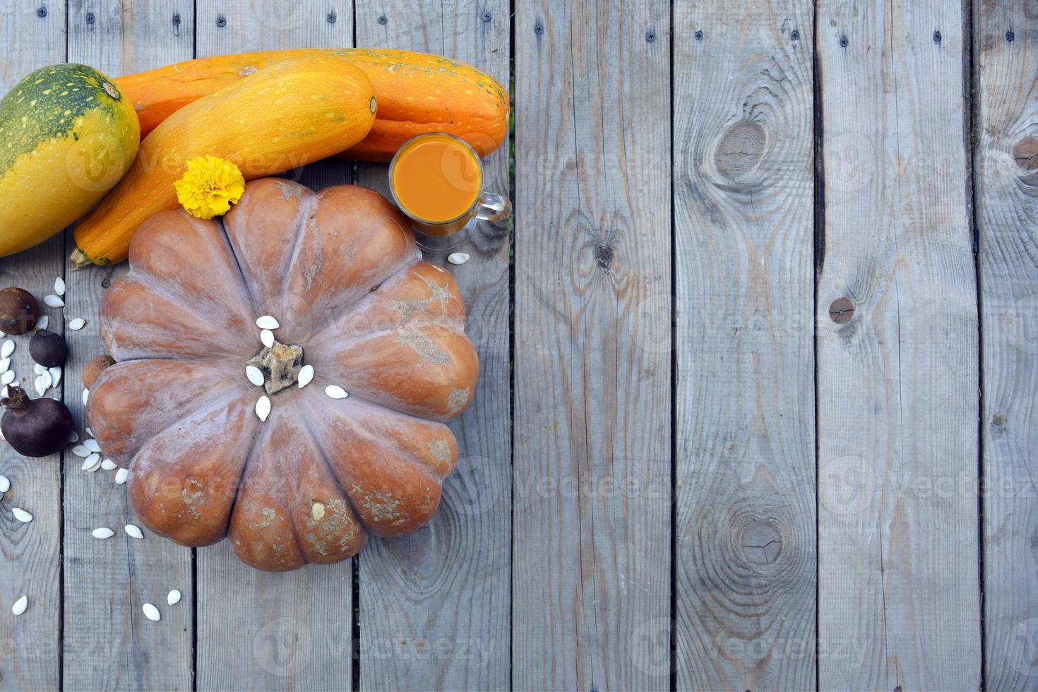 calabaza madura enorme con primer plano de semillas y verduras. la vista desde la cima. Fondo de madera horizontal con espacio para texto. foto