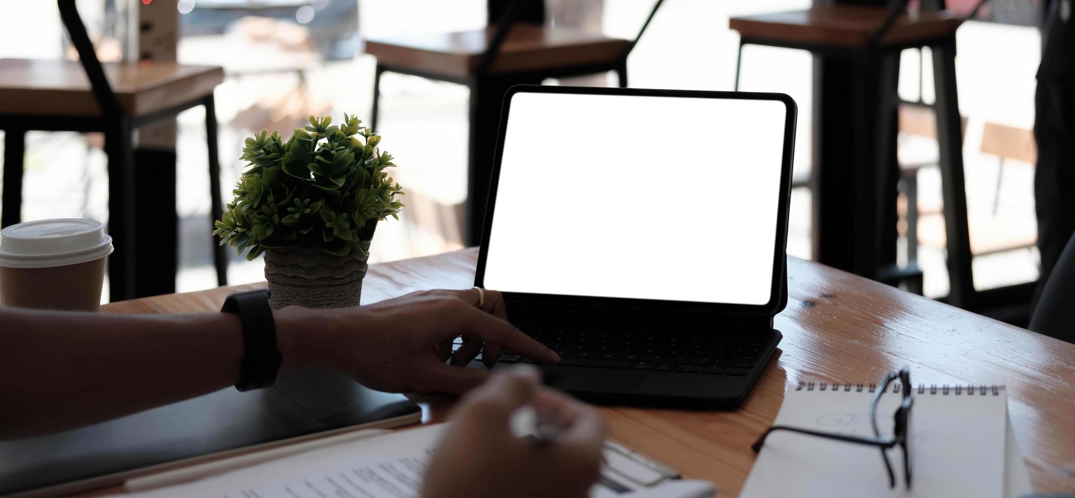 empresaria usando la pantalla en blanco de la computadora portátil mientras trabaja con la calculadora financiera. trazado de recorte foto
