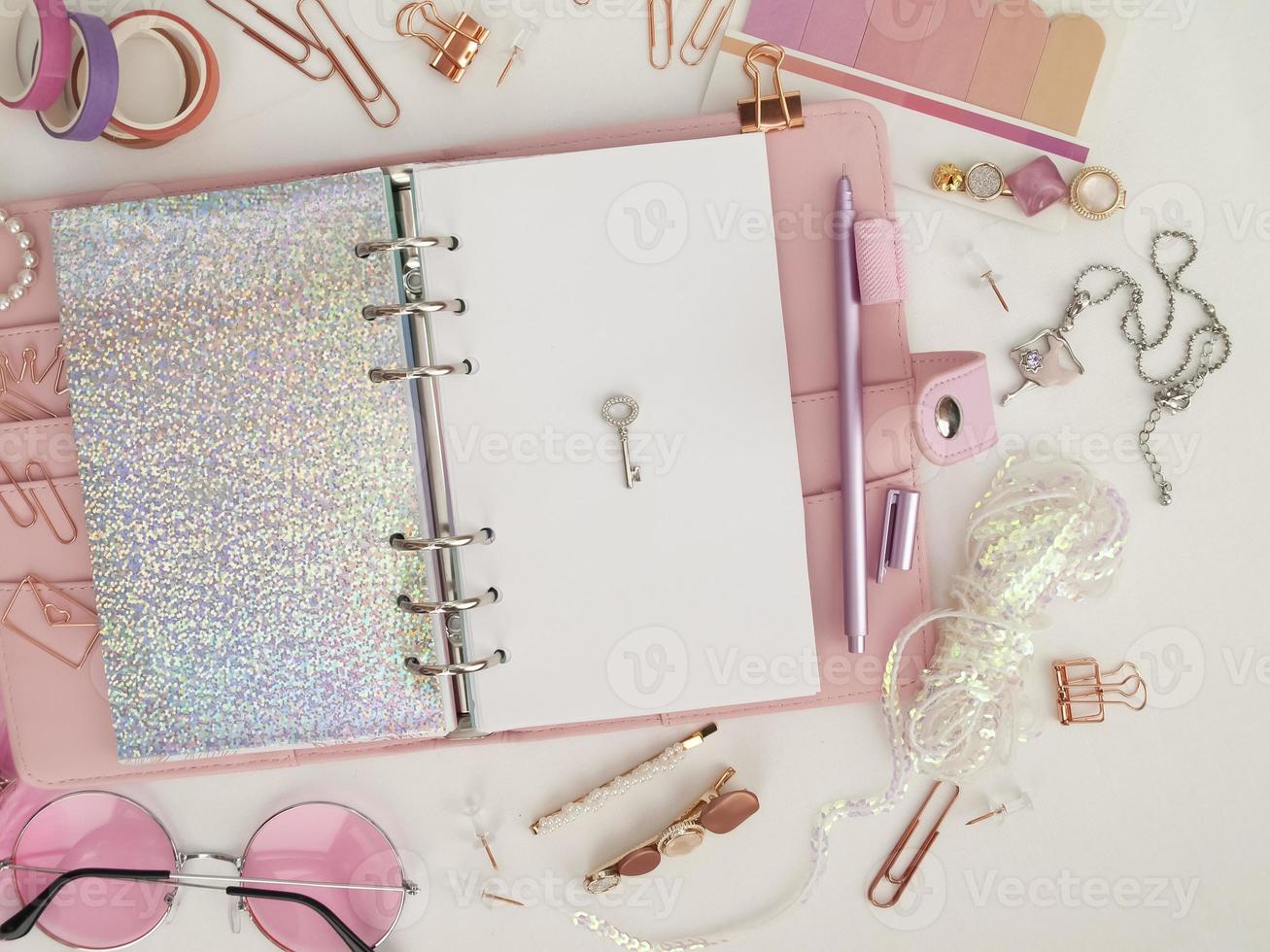 Silver key on the white page of the planner. Pink glamour planner decoration photo