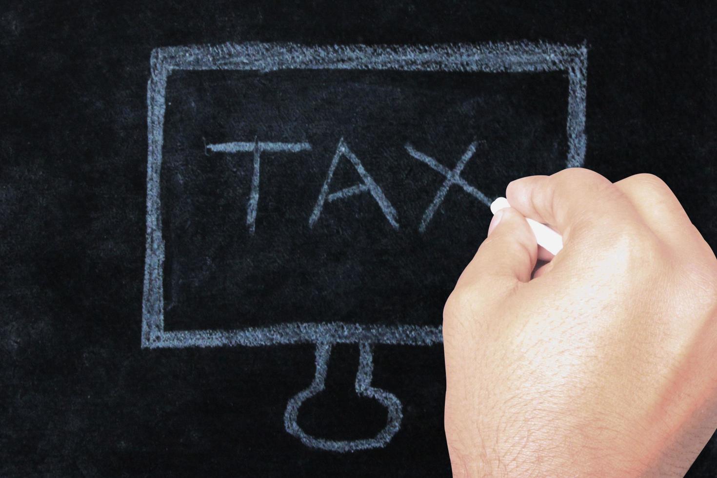 Hand writing tax words on the chalkboard photo