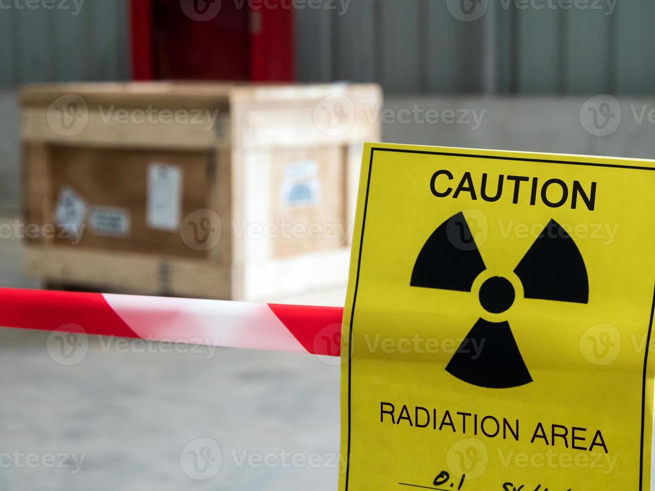 Radiation warning sign on the area warning tape around the Dangerous material package in the factory warehouse photo