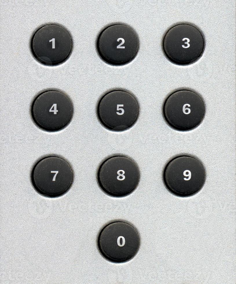 Number digits on a keypad with rubber buttons over grey metal background photo