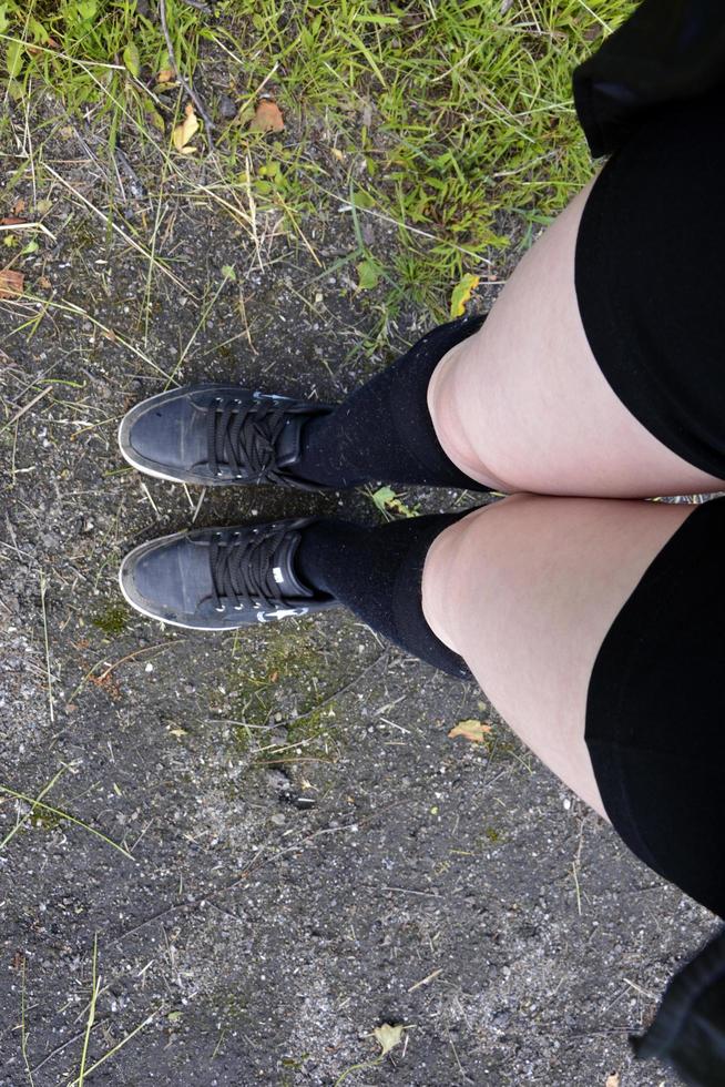 Legs of a teenage girl in black stockings. photo