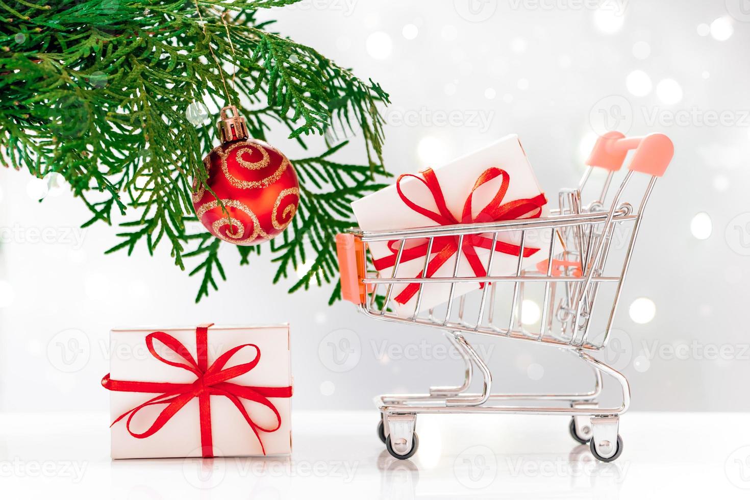 New Year shopping. Mini cart with gift boxes on white background. photo