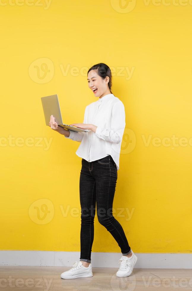 full body beautiful young asian girl, isolated on yellow background photo