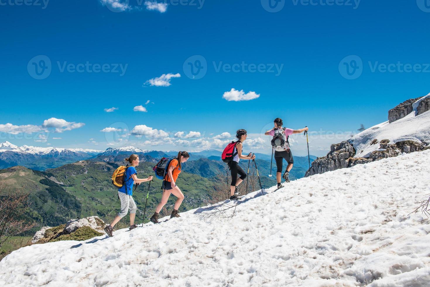 Group of girls walking on the snow in the mountains, in joy photo