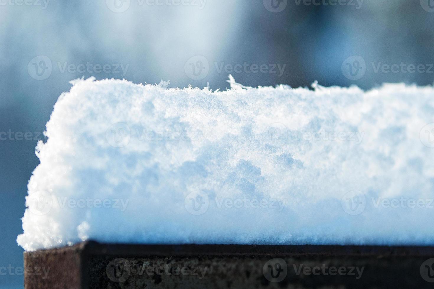 snow caps on the slabs of the fence photo