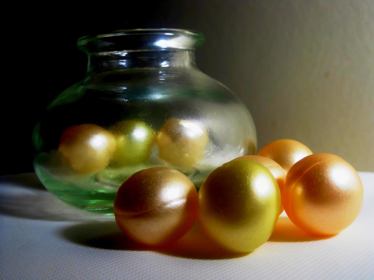 Colorful shinning beads alongside a jar photo