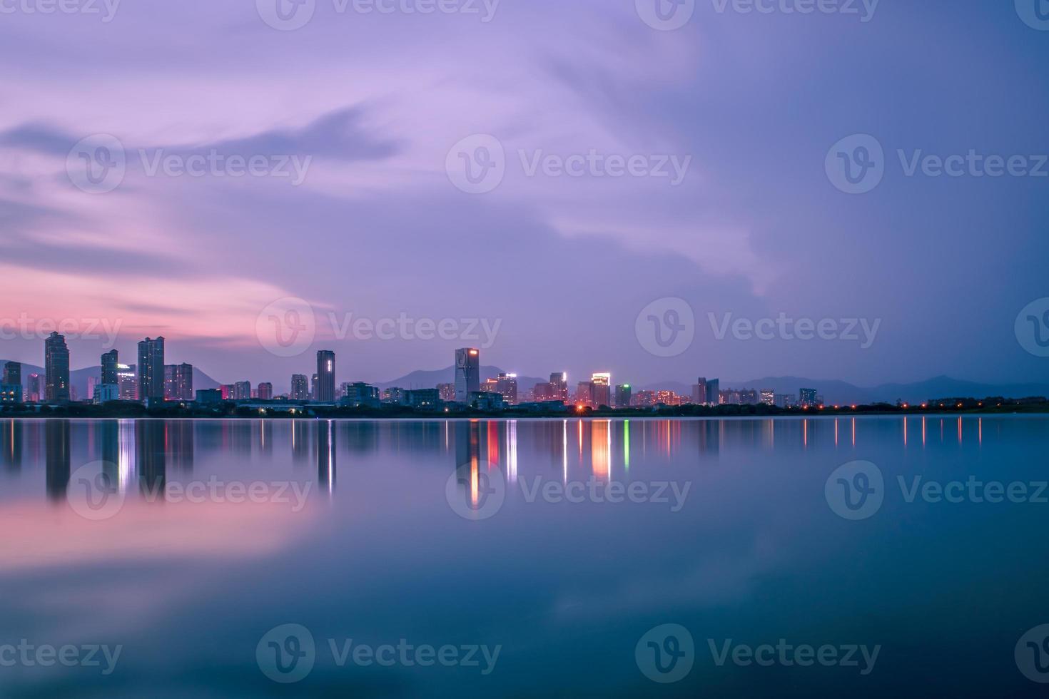 At dusk, the lake reflects the night view of the city photo