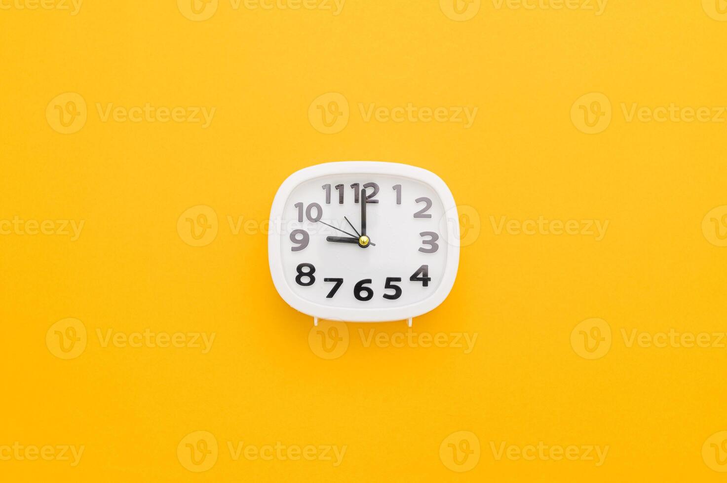 A clock on a yellow background with the time photo